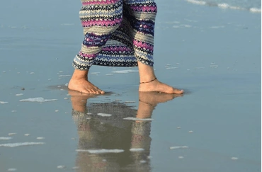 Photo of a woman walking in the sand, by Joy Feerrar